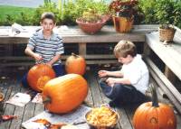 Colin carving his pumpkin with Matt